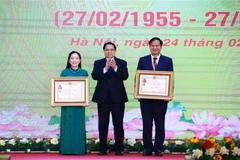 Le Premier ministre Pham Minh Chinh (centre) remet l’Ordre du travail de troisième classe au professeur associé Dr Dào Xuân Co, directeur de l’Hôpital Bach Mai, et le titre de docteure émérite à Nguyên Thi Mai Ngoc, à l’Institut national de cardiologie du Vietnam relevant de l’Hôpital Bach Mai. (Photo : VNA)