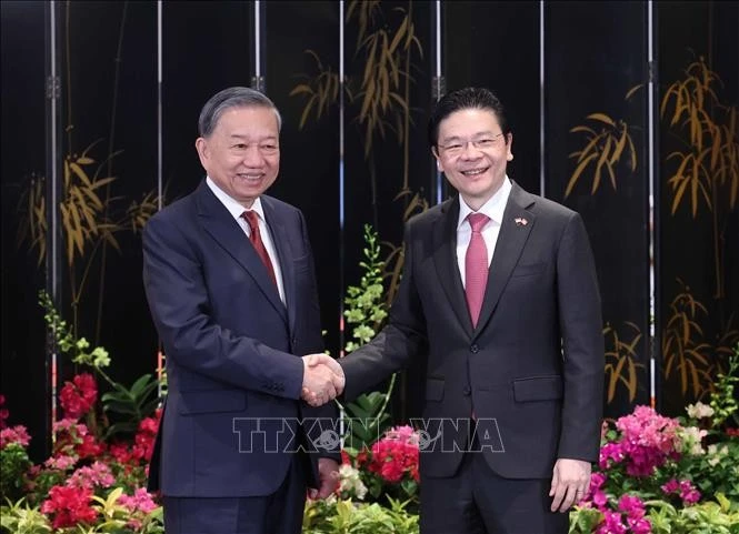 Le secrétaire général du Parti communiste du Vietnam, Tô Lâm (à gauche) et le Le Premier ministre singapourien Lawrence Wong se serrent la main. Photo: VNA