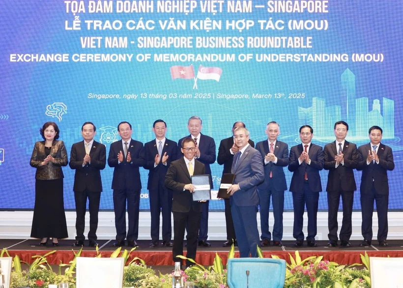 Échange du protocole d'accord de coopération entre Vietnam Airlines et Singapore Airport Terminal Services Limited (SATS). Photo: VNA