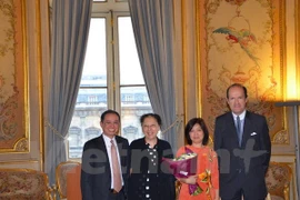 Mme Nguyên Thi Bich Huê (au centre, tunique traditionnelle de couleur orange) lors de la cérémonie. Photo: VNA